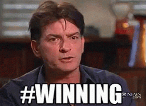 Man In Blue Shirt In Front Of #Winning Sign GIF