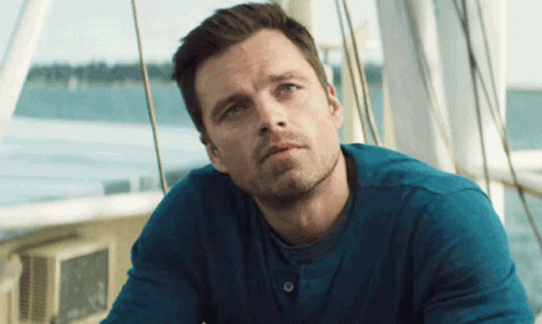 A Man In A Blue Shirt Is Sitting On A Boat Looking At The Water GIF