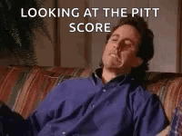 A Man In A Blue Shirt Is Sitting On A Couch With His Eyes Closed And Looking At The Pitt Score . GIF