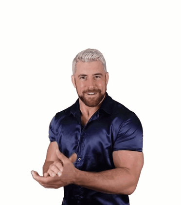 A Man In A Blue Shirt Is Smiling And Making A Funny Face GIF