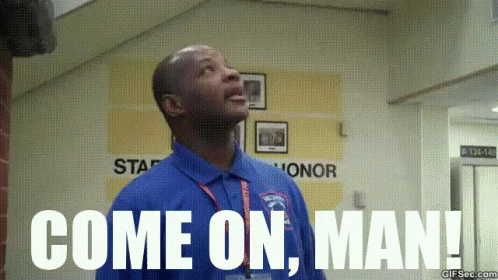 A Man In A Blue Shirt Is Standing In A Hallway And Says Come On Man . GIF