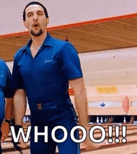 A Man In A Blue Shirt Is Standing In Front Of A Bowling Alley And Says Whooo ! GIF