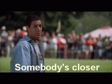 A Man In A Blue Shirt Is Standing In Front Of A Crowd Of People . GIF