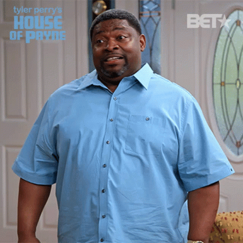 A Man In A Blue Shirt Is Standing In Front Of A Door That Says House Of Payne GIF