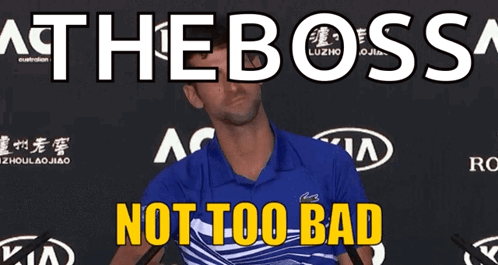 A Man In A Blue Shirt Is Standing In Front Of A Sign That Says " At The Boss " GIF
