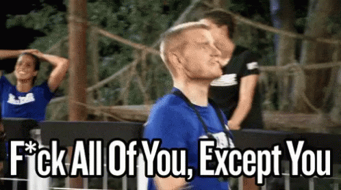 A Man In A Blue Shirt Is Standing In Front Of A Sign That Says " Fuck All Of You Except You " GIF