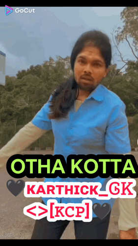 A Man In A Blue Shirt Is Standing In Front Of A Sign That Says Otha Kotta Karthick Gk Kcp GIF