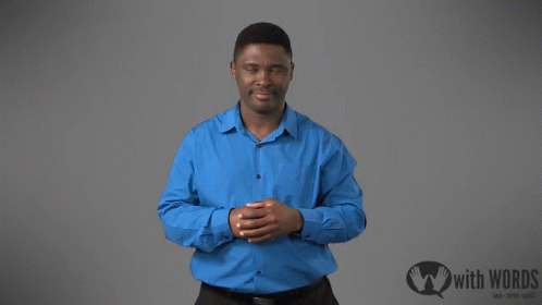 A Man In A Blue Shirt Is Standing In Front Of A Sign That Says " With Words " GIF