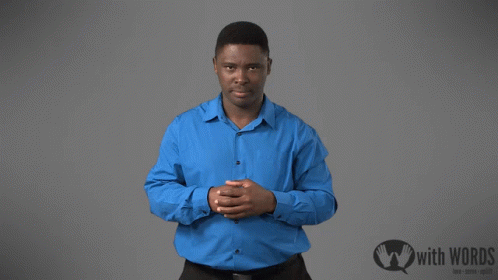 A Man In A Blue Shirt Is Standing In Front Of A Sign That Says " With Words " GIF