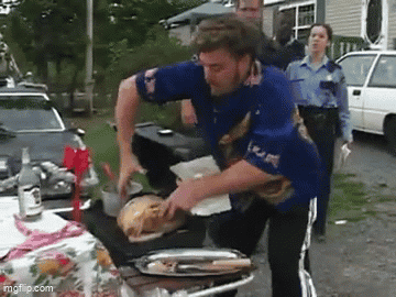 A Man In A Blue Shirt Is Standing In Front Of A Table With A Tray Of Food On It . GIF