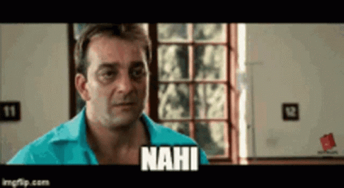 A Man In A Blue Shirt Is Standing In Front Of A Window And Says Nahi GIF