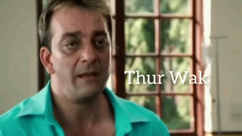 A Man In A Blue Shirt Is Standing In Front Of A Window With The Word Thur Wak Written On The Bottom GIF