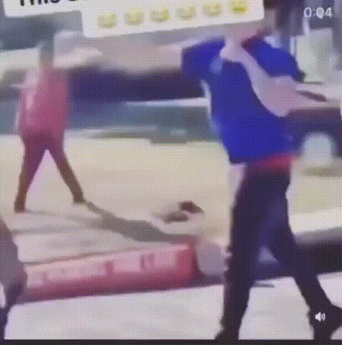 A Man In A Blue Shirt Is Standing Next To A Woman In A Red Shirt In A Blurry Photo . GIF