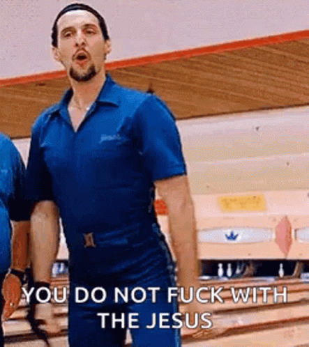 A Man In A Blue Shirt Is Standing On A Bowling Alley . GIF