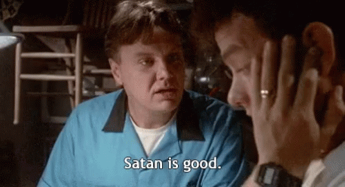 A Man In A Blue Shirt Is Talking On A Cell Phone To Another Man . GIF