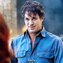 A Man In A Blue Shirt Is Talking To A Woman And Says `` Sorry '' . GIF