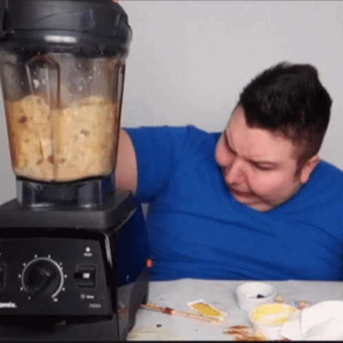 A Man In A Blue Shirt Is Using A Vitamix Blender To Make Food GIF