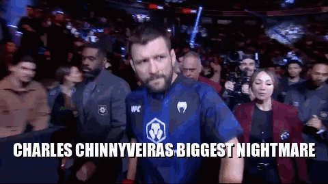 A Man In A Blue Shirt Is Walking Out Of A Boxing Ring . GIF