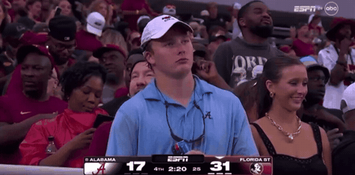 A Man In A Blue Shirt Is Watching A Game On Espn GIF