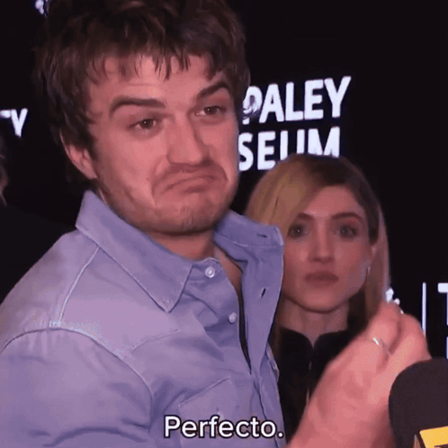 A Man In A Blue Shirt Says Perfecto In Front Of A Paley Museum Sign GIF