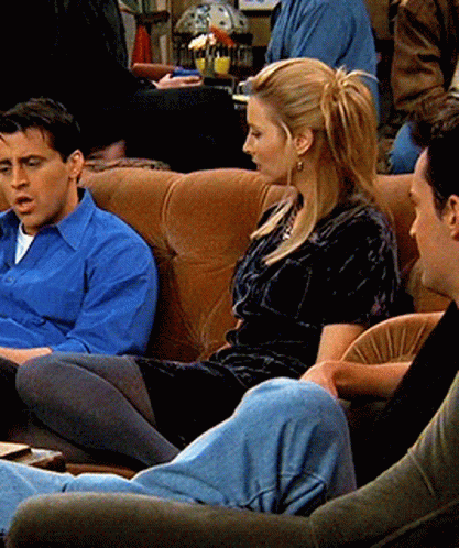A Man In A Blue Shirt Sits Next To A Woman In A Black Dress GIF