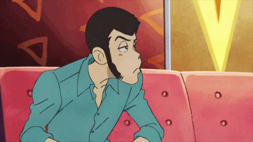 A Man In A Blue Shirt Sits On A Pink Couch GIF