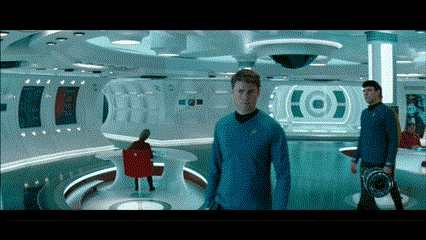A Man In A Blue Shirt Stands In A Room With A Target On The Wall Behind Him GIF