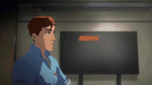 A Man In A Blue Shirt Stands In Front Of A Large Screen That Says Sdn GIF