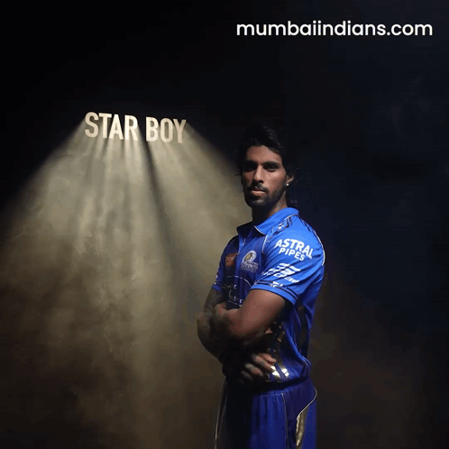 A Man In A Blue Shirt Stands In Front Of A Spotlight That Says Star Boy GIF
