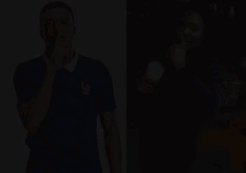 A Man In A Blue Shirt With A Rooster On It Holds His Finger To His Lips GIF