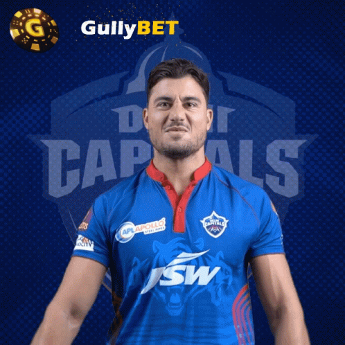 A Man In A Blue Shirt With The Word Capitals On The Front GIF
