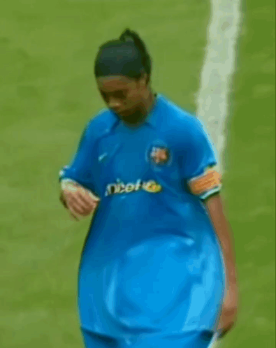 a man in a blue shirt with unicef on it is walking on a field .