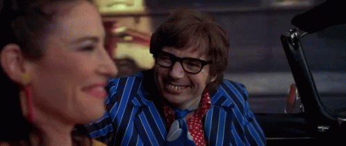 A Man In A Blue Striped Suit And Tie Is Smiling While Sitting In A Car Next To A Woman . GIF