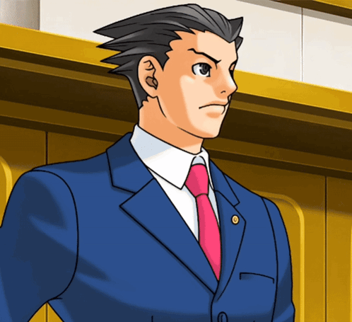 A Man In A Blue Suit And Pink Tie Stands In Front Of A Wall GIF