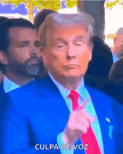 a man in a blue suit and red tie says " culpa de voz " on the bottom