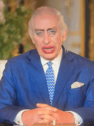 A Man In A Blue Suit And Tie Is Making A Funny Face With His Eyes Closed GIF