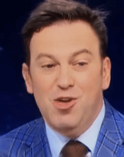A Man In A Blue Suit And Tie Is Smiling GIF