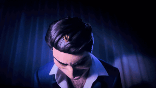 A Man In A Blue Suit And White Shirt Is Making A Funny Face GIF
