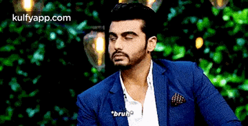 A Man In A Blue Suit And White Shirt Is Talking To Someone . GIF