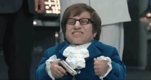 A Man In A Blue Suit Holds A Gun GIF