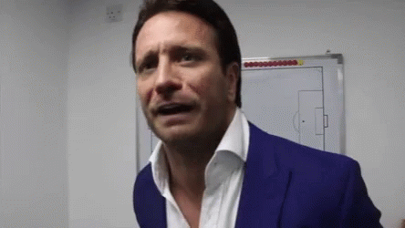 A Man In A Blue Suit Is Standing In Front Of A White Board With A Soccer Field Drawn On It GIF