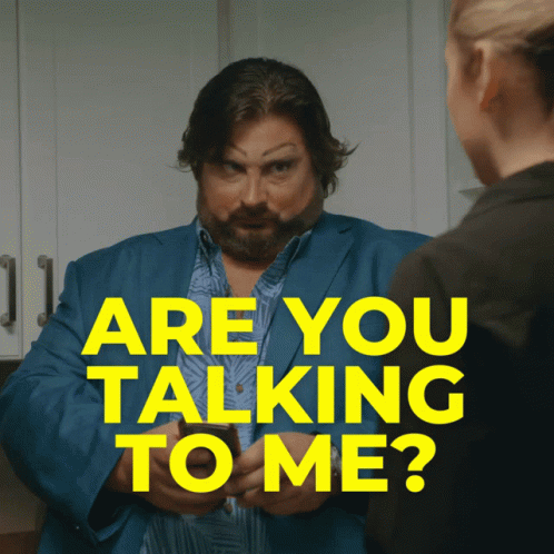A Man In A Blue Suit Is Talking To A Woman With The Words " Are You Talking To Me " Above Him GIF