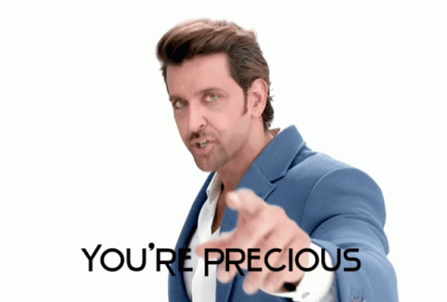 A Man In A Blue Suit Pointing At The Camera With The Words You 'Re Precious Behind Him GIF