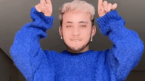 A Man In A Blue Sweater Is Giving A Thumbs Up Sign GIF