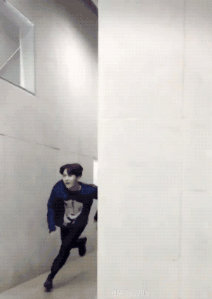 A Man In A Blue Sweater Is Running Between Two Walls GIF
