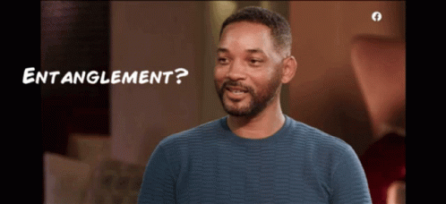 A Man In A Blue Sweater Is Smiling With The Words " Entanglement " Below Him GIF