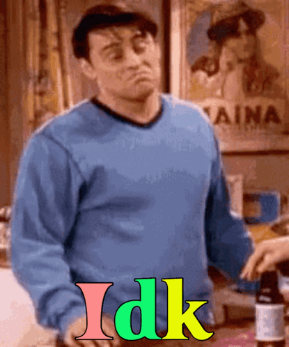 A Man In A Blue Sweater Is Standing In Front Of A Sign That Says " Aina " GIF