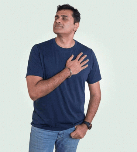 A Man In A Blue T-Shirt Is Holding His Hand To His Chest GIF