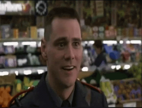 A Man In A Blue Uniform Is Smiling In Front Of A Grocery Store GIF