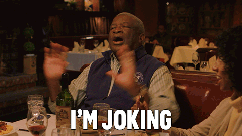 A Man In A Blue Vest Says I 'M Joking In A Restaurant GIF